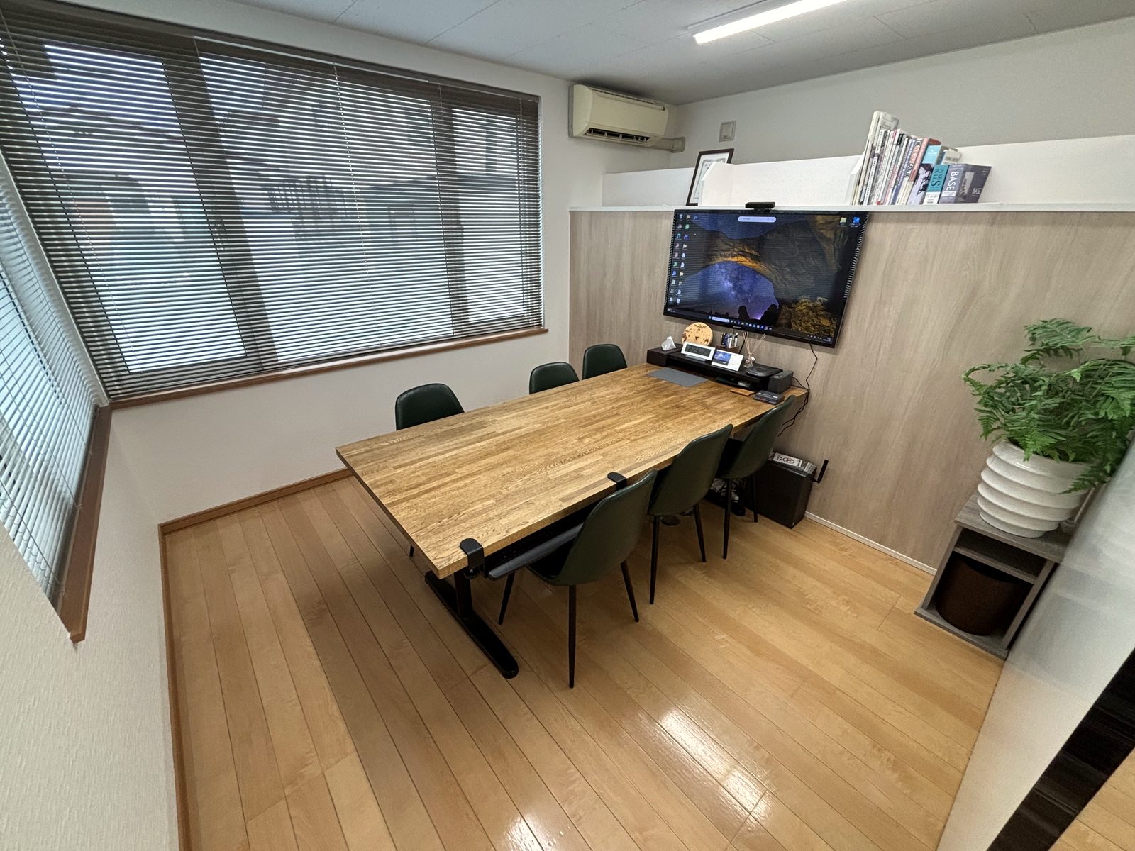 事務所内のご相談スペース。木のテーブルと椅子が並ぶ明るい部屋